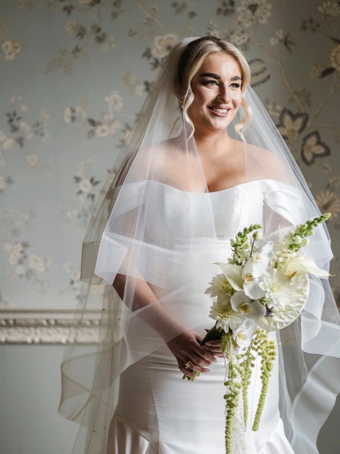 Knowsley hall bride holding a sculptural white bridal bouquet with hanging Amaranthus